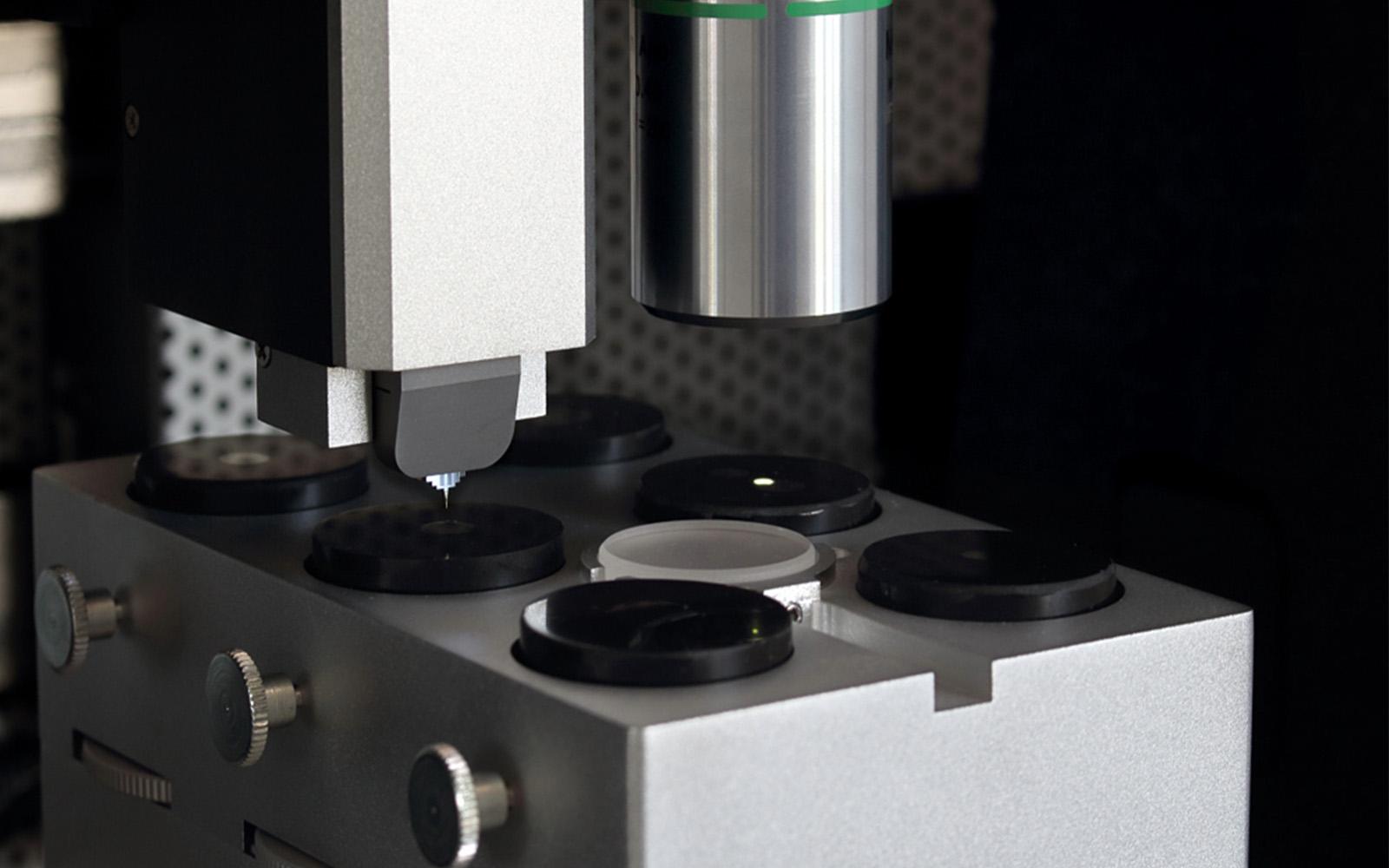 <p>i04 Femto-Indenter positioning its tip above sample holders for precision measurement.</p>